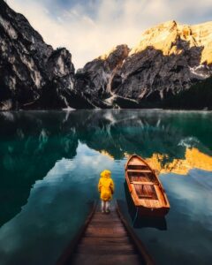 A peaceful lake surrounded by mountains with a dock and boat, perfect for adventure and reflection.